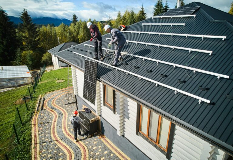 Professional workers lifting solar panel on a roof of house